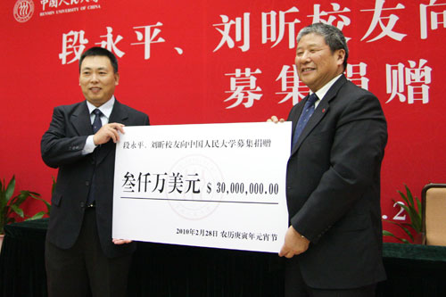 段永平向紀寶成校長(右)遞交捐贈支票 段永平向紀寶成校長(右)遞交捐贈支票